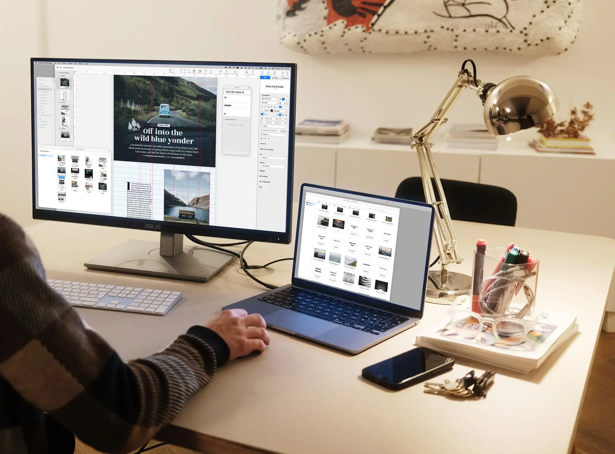 Shot over the shoulder of a designer working in the pagestrip software, using two screens, one showing a layout, the other a media asset manager. In the background, there's a stylish office.